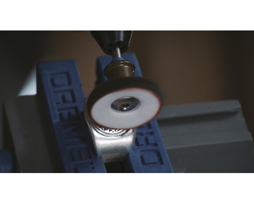 Outil Dremel polissant une bague en métal dans un étau
