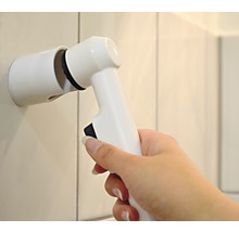 Brosse de nettoyage électrique avec support mural dans une main