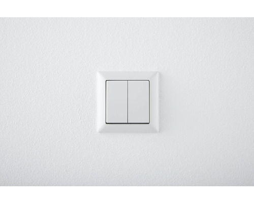 Double interrupteur blanc sur un mur