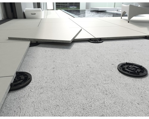 Pose de dalles de terrasse sur plots dans l''espace extérieur.