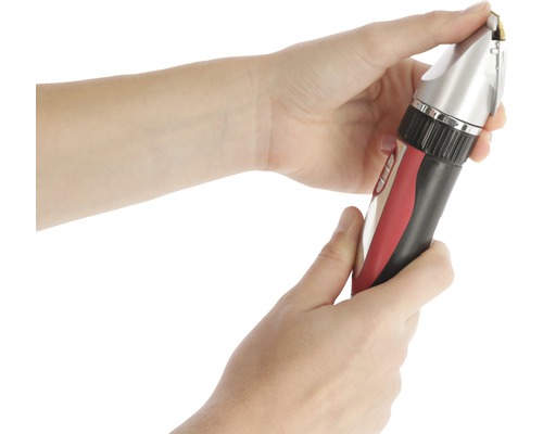 Eine Person hält eine Haarschneidemaschine in der Hand.