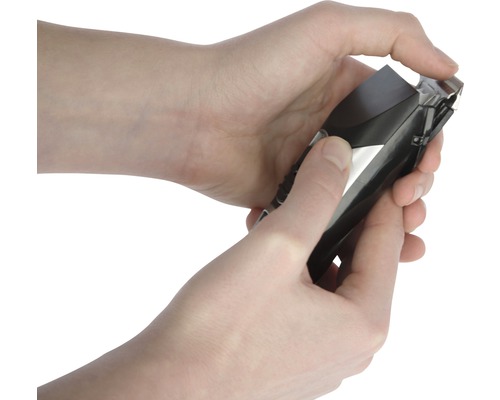 Hände halten eine Haarschneidemaschine