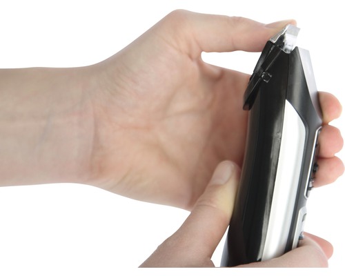 Hand hält Haarschneidemaschine