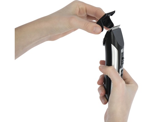 Hände befestigen einen Aufsatz an einem Haarschneider