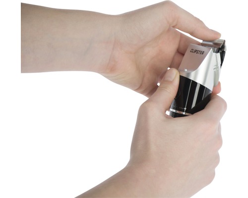 Eine Person wechselt den Scherkopf einer Haarschneidemaschine.