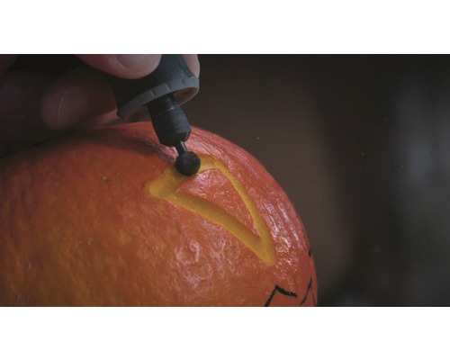 Personne sculptant une citrouille avec un outil multifonction