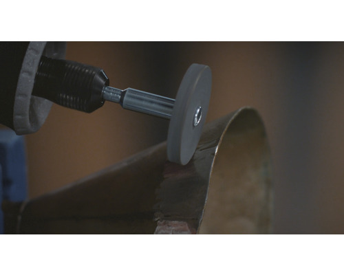 Outil rotatif polissant un objet métallique.