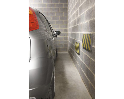 Voiture garée dans un garage avec protection murale
