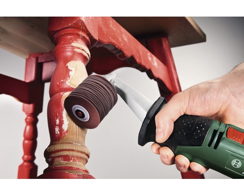 Une main ponce des pieds de table rouges avec un outil électrique