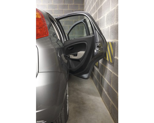 Voiture dans un garage avec porte ouverte et butée de protection murale