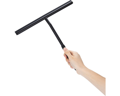 Une main tient un racloir de douche noir