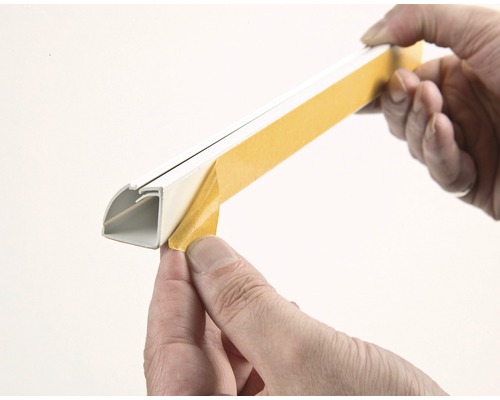 Person entfernt Schutzfolie von einer Kabelführungsschiene.