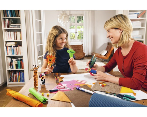 Une mère et sa fille fabriquent des figurines d''animaux avec du feutre et de la colle sur une table