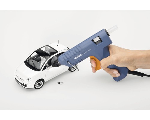 Pistolet à colle chaude collant une voiture jouet