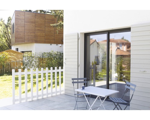 Terrasse mit Gartenmöbeln, Zaun und Hausfassade