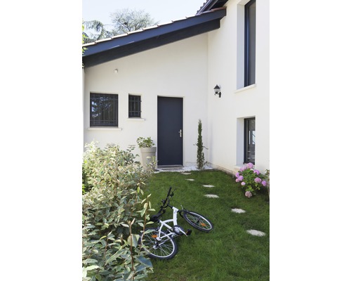 Aussenansicht eines Hauses mit Garten, Rasenfläche, Gehwegplatten und einem Fahrrad