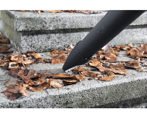 Gros plan d''un aspirateur à feuilles ramassant des feuilles sur un escalier en pierre