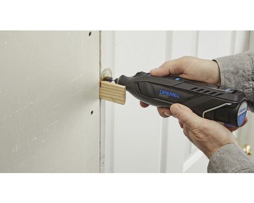 Une personne utilise un outil multifonction Dremel pour poncer du bois.