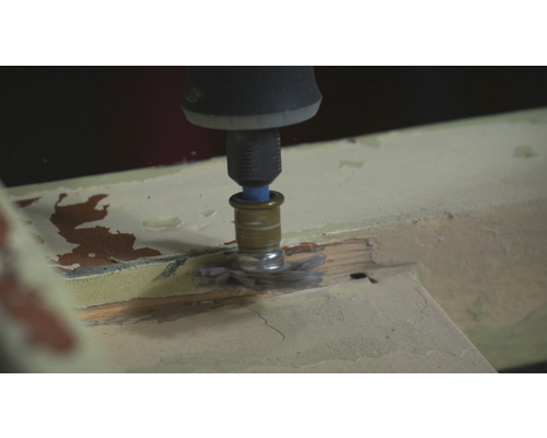 Un outil multifonction avec une brosse ponce le bois.