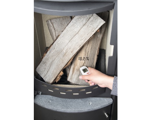 Holzfeuchtemessgerät misst den Feuchtigkeitsgehalt von Brennholz im Ofen