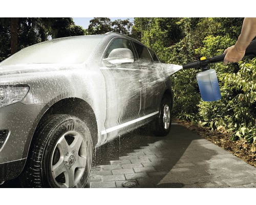 Une voiture est nettoyée avec un nettoyeur haute pression et un détergent.