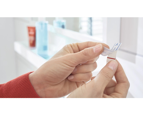 Une personne retire le film protecteur d''une bande adhésive.