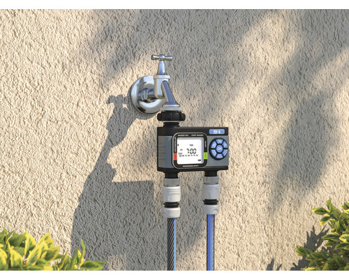 Bewässerungsuhr am Wasserhahn mit zwei angeschlossenen Wasserschläuchen