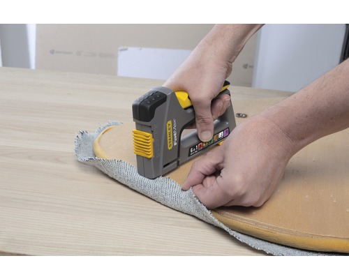 Stanley Logo Tacker beim Befestigen eines Stoffs an einem Stuhl