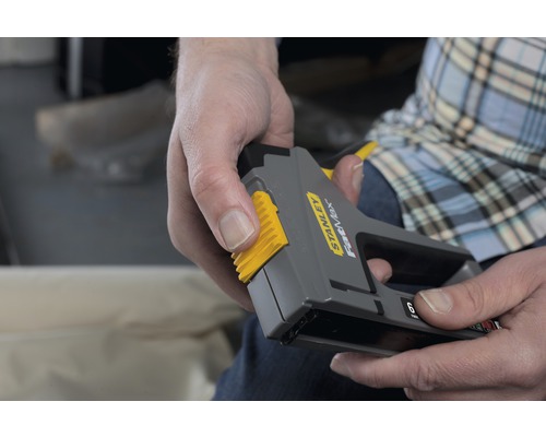 Eine Person bedient einen Stanley Fastmax Tacker.