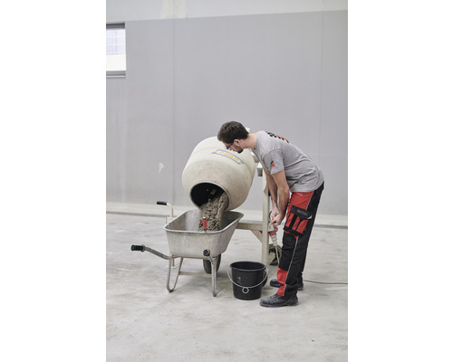 Betonmischer befüllt Schubkarre mit Beton