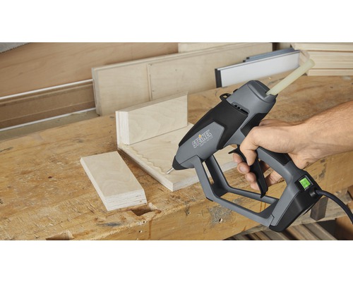 Eine Steinel Heissklebepistole beim Verkleben von Holzstücken