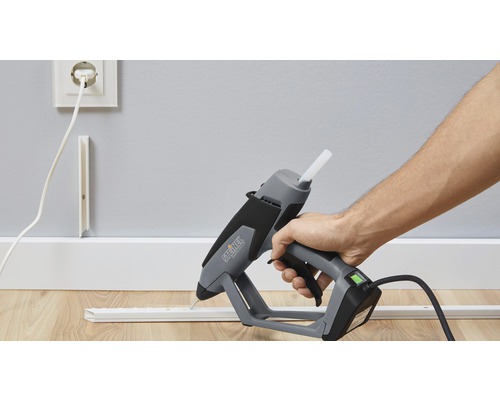 Pistolet à colle chaude utilisé pour fixer une moulure décorative