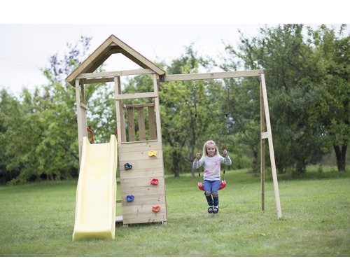 Aire de jeux avec toboggan, mur d''escalade et balançoire dans le jardin