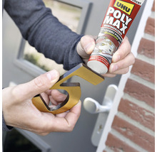 Eine Person befestigt eine goldfarbene Hausnummer mit Montagekleber.