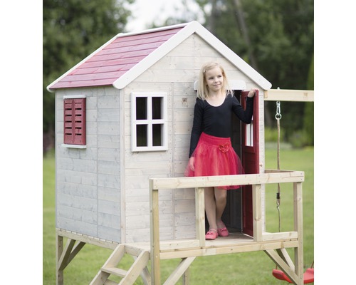 Cabane en bois sur pilotis avec toit rouge pour enfants dans le jardin