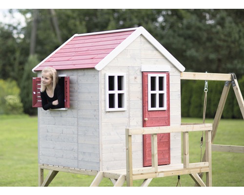 Maisonnette en bois avec balançoire et enfant regardant