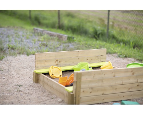 Bac à sable en bois avec jouets dans le jardin