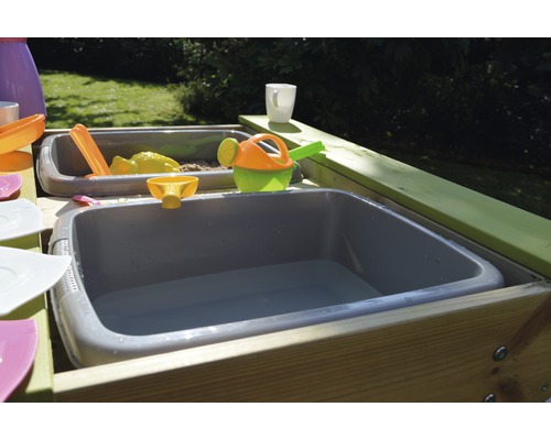 Table à sable et à eau avec jouets dans le jardin