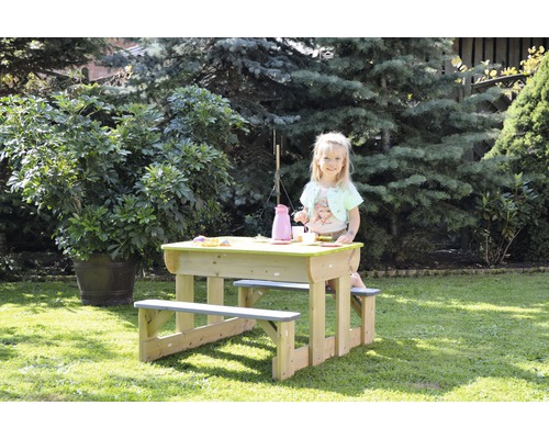 Enfant à un groupe de sièges pour enfants dans le jardin