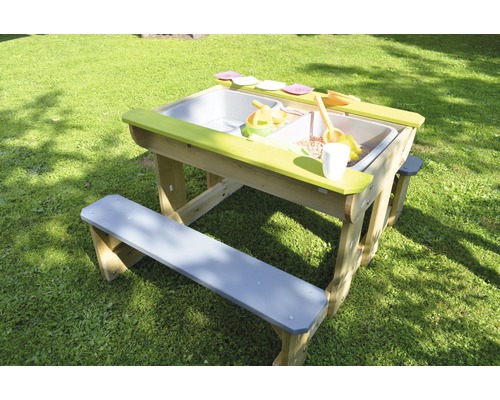 Table à sable et à eau avec bancs et jouets dans le jardin
