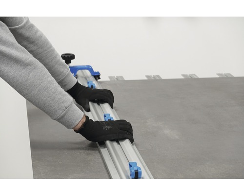 Une personne utilise une carrelette pour couper des carreaux