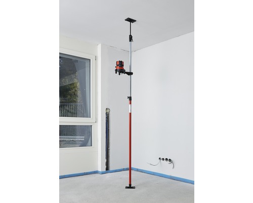 Kreuzlinienlaser mit Stativstange in einem Raum