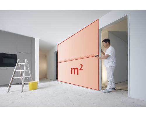 Mann misst mit einem Laser-Entfernungsmesser die Wandfläche zur Berechnung der Quadratmeterzahl.