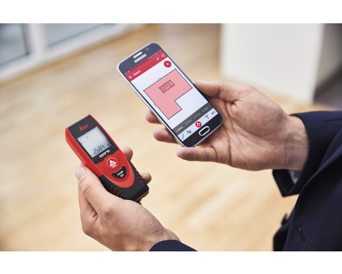 Person hält Laser-Entfernungsmesser und Smartphone mit Raumplan-App