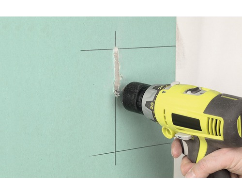 Bohrmaschine bohrt ein Loch in eine Gipskartonwand