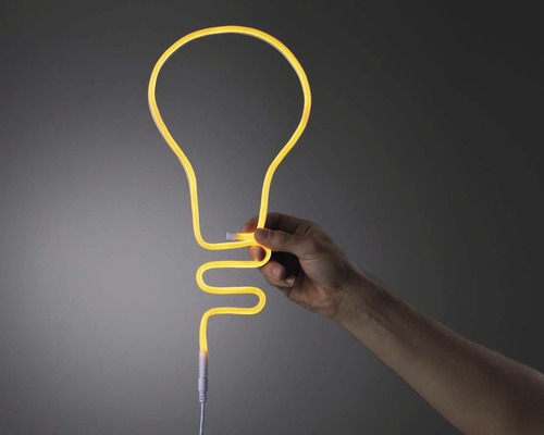 Main tenant une lampe néon en forme d''ampoule