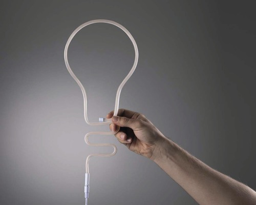 Une main tient une lampe serpentin en forme d''ampoule.