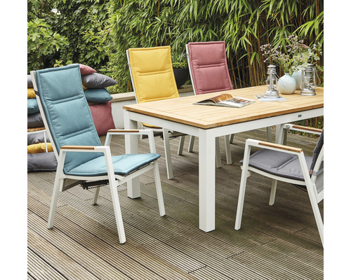 Scène de jardin avec table à manger, chaises et coussins à l''extérieur