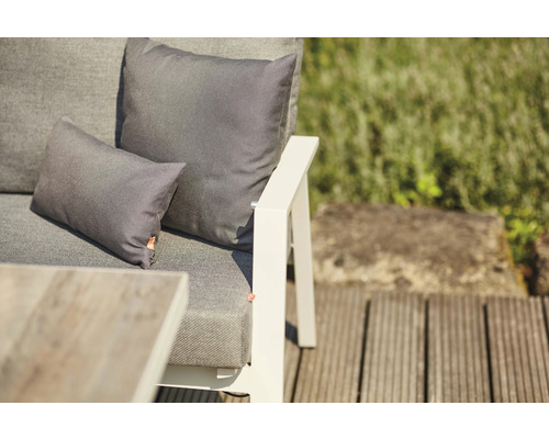 Vue détaillée de mobilier de jardin avec coussins sur une terrasse en bois.
