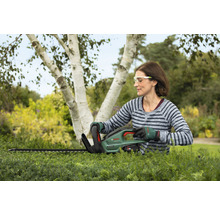 Frau schneidet Hecke mit Akku-Heckenschere von Bosch